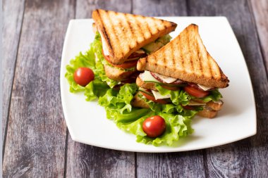 Ahşap arka plan üzerinde peynir, domates, salatalık, sosis ve salata ile Sandviç. Yatay yönlendirme