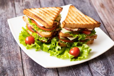 Ahşap arka plan üzerinde peynir, domates, salatalık, sosis ve salata ile Sandviç. Yatay yönlendirme