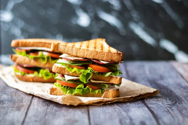 Sandwich with cheese, tomato, cucumber, sausage and salad on wooden background. Horizontal orientation — Stock Photo, Image