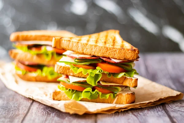 Sandwich with cheese, tomato, cucumber, sausage and salad on wooden background. Horizontal orientation — Stock Photo, Image