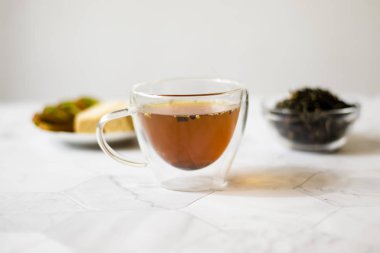 Hafif bir arka plan üzerinde şeffaf bir kupa yasemin ile yeşil çay. Yatay yönlendirme