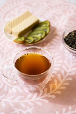 Hafif bir arka plan üzerinde şeffaf bir kupa yasemin ile yeşil çay. Dikey yönlendirme
