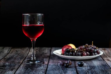 Pembe şarap. Meyve ve üzüm yakınında bir bardak şarap. Eski teknolojiye göre geleneksel Gürcü şarabı. Kopyalama alanı Yukarı ve dikey yönlendirme.