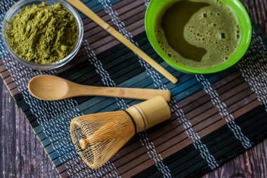 ahşap bir yüzey üzerinde bir kase yeşil çay matcha. Üst görünüm, antioksidanlar, detoks içerir. Yatay yönlendirme