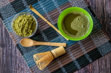ahşap bir yüzey üzerinde bir kase yeşil çay matcha. Üst görünüm, antioksidanlar, detoks içerir. Yatay yönlendirme