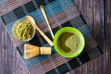 ahşap bir yüzey üzerinde bir kase yeşil çay matcha. Üst görünüm, antioksidanlar, detoks içerir. Yatay yönlendirme