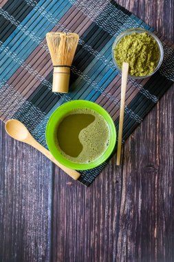 ahşap bir yüzey üzerinde bir kase yeşil çay matcha. Üst görünüm, antioksidanlar, detoks içerir. Dikey yönlendirme