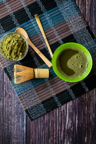 Ahşap bir yüzey üzerinde bir kase yeşil çay matcha. Üst görünüm, antioksidanlar, detoks içerir. Dikey yönlendirme — Stok fotoğraf