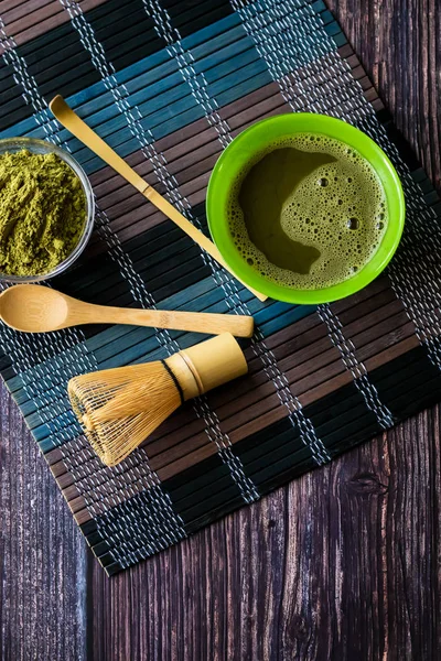 Ahşap bir yüzey üzerinde bir kase yeşil çay matcha. Üst görünüm, antioksidanlar, detoks içerir. Dikey yönlendirme — Stok fotoğraf