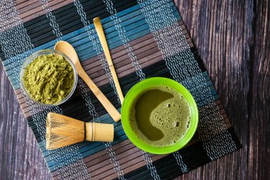ahşap bir yüzey üzerinde bir kase yeşil çay matcha. Üst görünüm, antioksidanlar, detoks içerir. Yatay yönlendirme