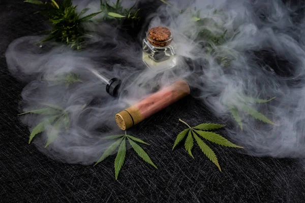 Líquido de cannabis. Vape CBD o THC, Vaping Marihuana y Cáñamo. Contra un fondo oscuro. Vapor grueso. Orientación horizontal —  Fotos de Stock