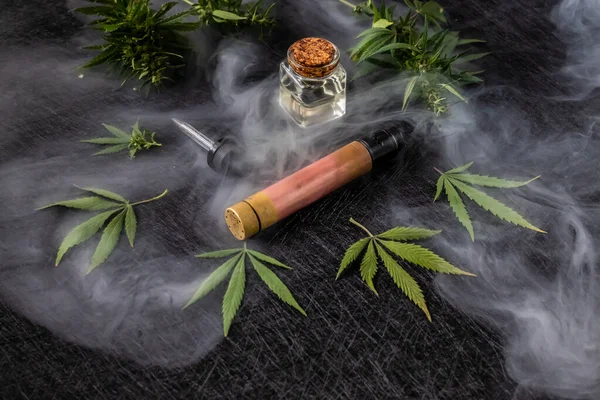 Cannabis liquid. Vape CBD or THC, Vaping Marijuana and Hemp. Against a Dark Background. Mist of steam. — Stock Photo, Image