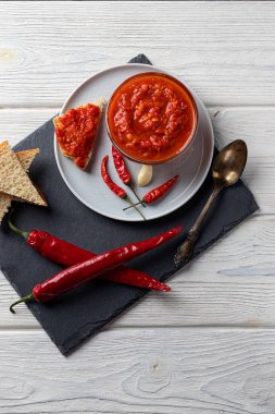 Ahşap arka planda acı biber ve harissa biberi soslu geleneksel Maghribi. Tunus ve Arap mutfağı Adjika. Dikey yönelim