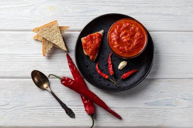 Acı biber ve soslu Harissa makarnası. Adjika. Geleneksel Tunus, Gürcü ve Arap mutfağı. Ev yapımı Harissa bir kasede yükseldi. Uzayı kopyala düz yatay, üst görünüm.