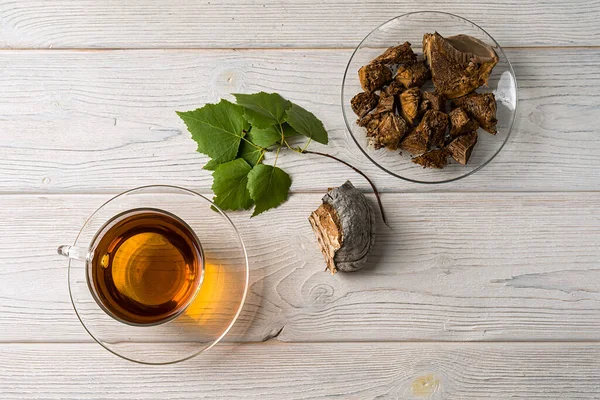 Café saludable de moda con champiñones chaga. Setas secas y ramas de abedul sobre un fondo rústico. Copiar espacio, vista superior . — Foto de Stock