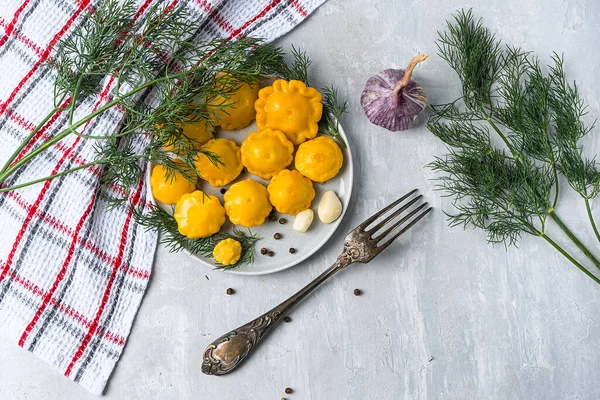 Pequeno squash marinado com pimenta, alho e endro, caseiro. Em um fundo de pedra cinza claro com têxteis. Vista de cima. Espaço de cópia — Fotografia de Stock