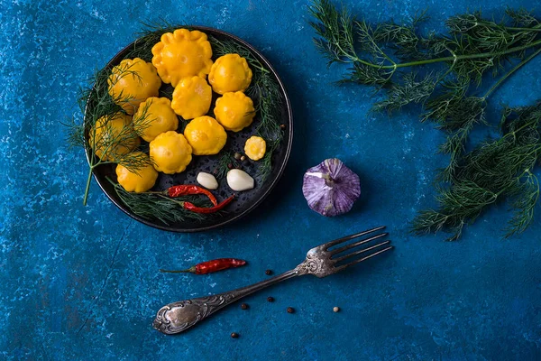 Mini-squash marinado com pimenta, alho e endro, caseiro. Numa mesa azul. Vista de cima. Espaço para cópia. Orientação horizontal — Fotografia de Stock