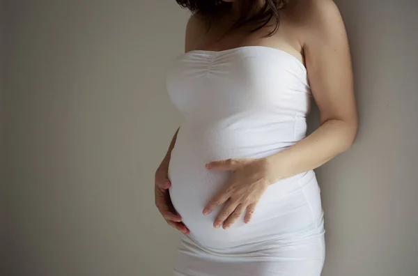 Grávida jovem mulher detalhes barriga em vestido branco — Fotografia de Stock