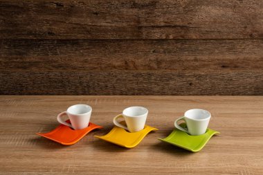 Hafif ahşap bir tahta üzerinde beyaz porselen kahve fincanları