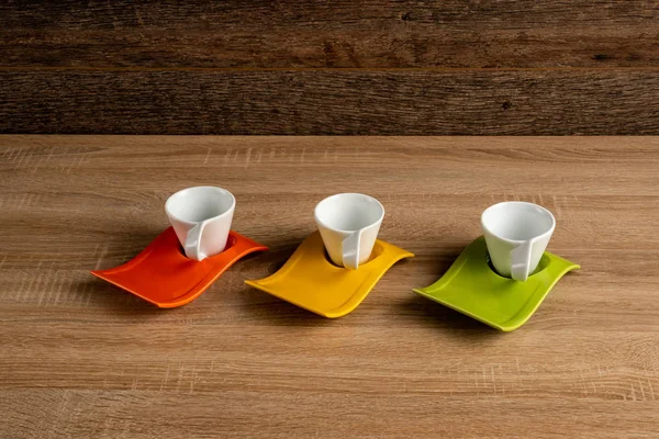 Louça de café de cor laranja, amarela e verde em uma mesa — Fotografia de Stock