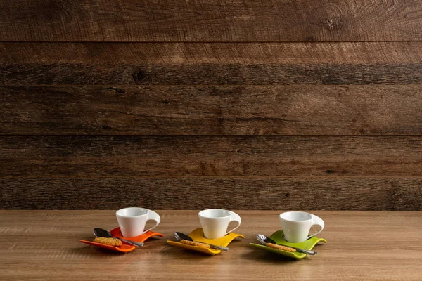 Trois tasses à café vides avec biscuit et cuillère à café à proximité — Photo