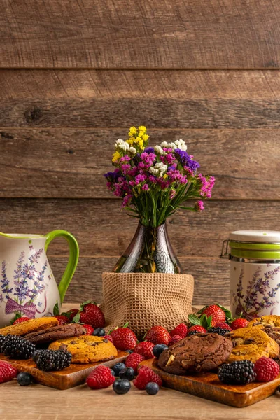 Flower vase, ceramic vessels with assorted mix of wild fruits and cookies