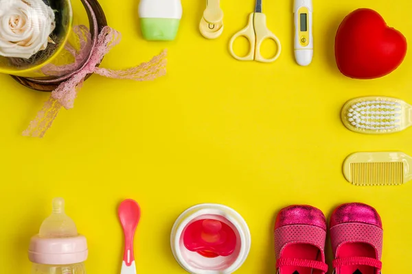 Потребности в уходе за детьми и посуда на желтом фоне — стоковое фото