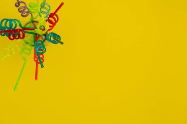 Sarı arka planda spiral pipetler, üst görünüm