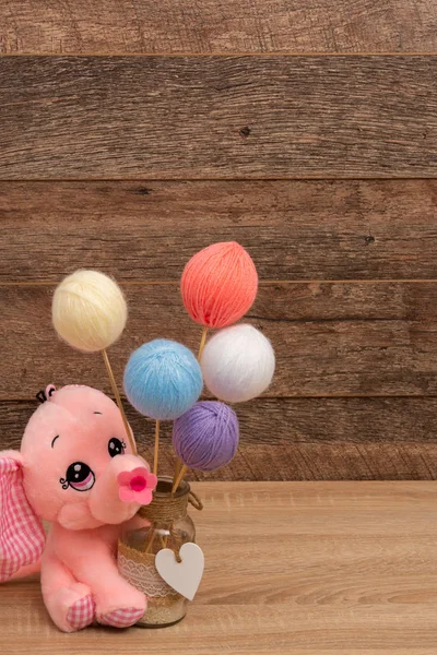 Garnbollar på pinnar och rosa baby leksak — Stockfoto