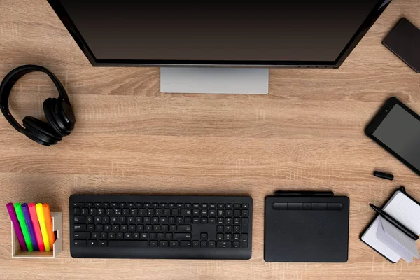 Black headphones with keyboard, tablet and notebook