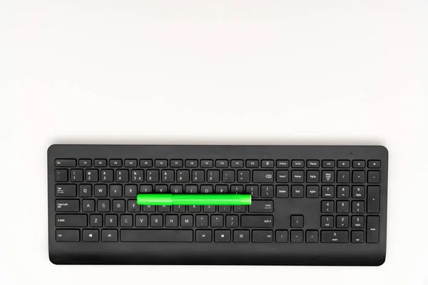 Marcador verde y teclado negro sobre fondo blanco —  Fotos de Stock