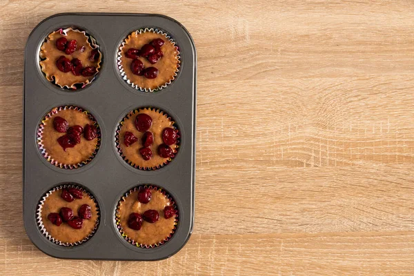 Vue du dessus du muffin cerise aigre cru dans la plaque à pâtisserie — Photo