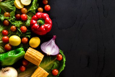 Sebzeler siyah masaya dizilmiş, sağda boş alan var.
