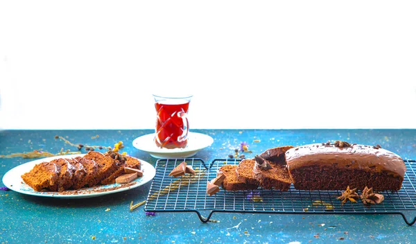 Τραπέζι με σοκολάτα και φέτες κέικ δίπλα στο κομμένο γλασαρισμένο επιδόρπιο — Φωτογραφία Αρχείου