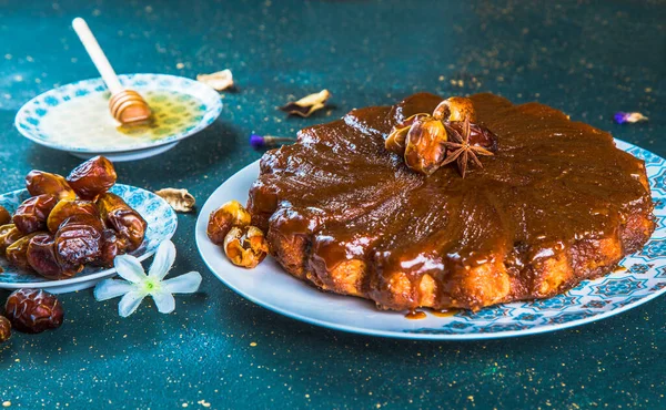 Gâteau avec glaçure et dates sur table avec miel — Photo