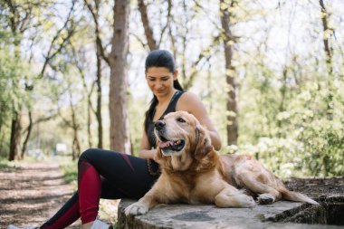 Kızla birlikte ağaç kütüğünde yatan köpek.