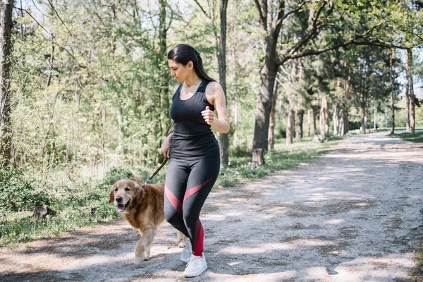 Spor kızı köpeğini dolaştırıyor. — Stok fotoğraf