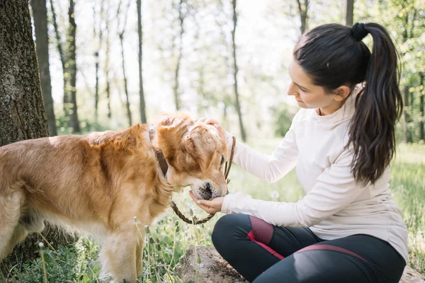 Chica acariciando perro que está comiendo comida de su mano — Foto de Stock