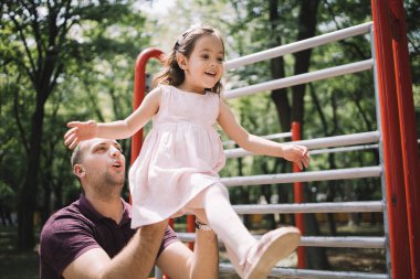 Babası kızını kollarında tutuyor.