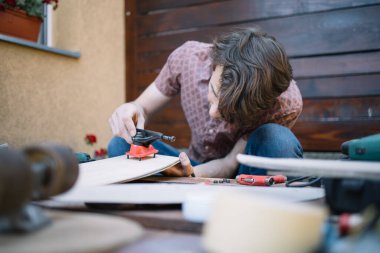 Konsantre adam güverteye kaykay kamyonu koyuyor.