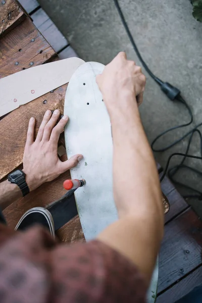 High angle view of mans hands polishing board outdoor — Stock Photo, Image