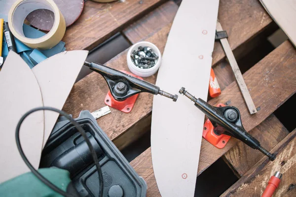 Draufsicht auf Werkzeuge und Schrauben auf Tisch mit Skateboard-Deck und LKW — Stockfoto