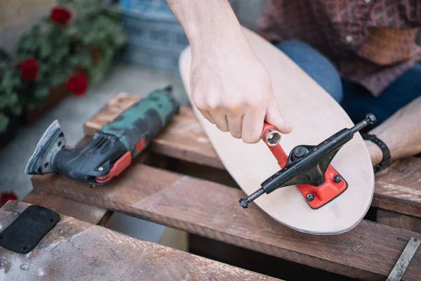 Manliga handmonterade skateboard lastbilar med skruvmejsel Stockfoto