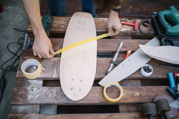 Mans hands sticking paper tape to wooden board — Stock Photo, Image