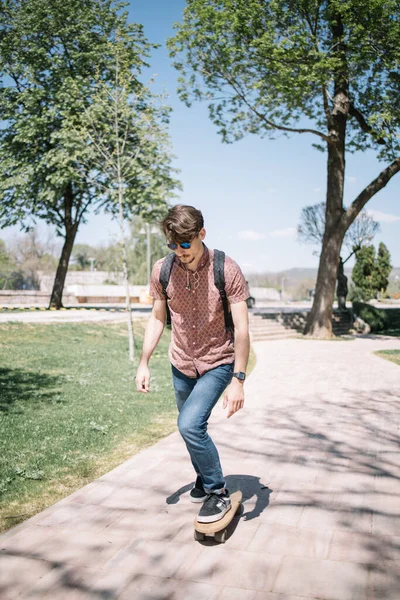 Junger Mann fährt Skateboard in Park — Stockfoto