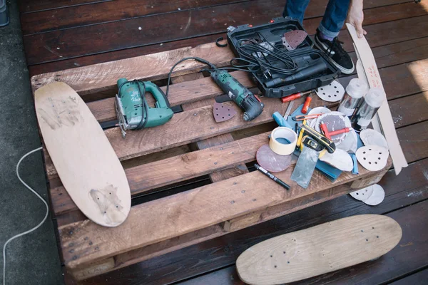 Top view of wooden pallet with handyman tools and skateboards — Stock Photo, Image