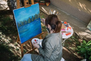 Açık havada resim yapan kadının yüksek açılı görüntüsü