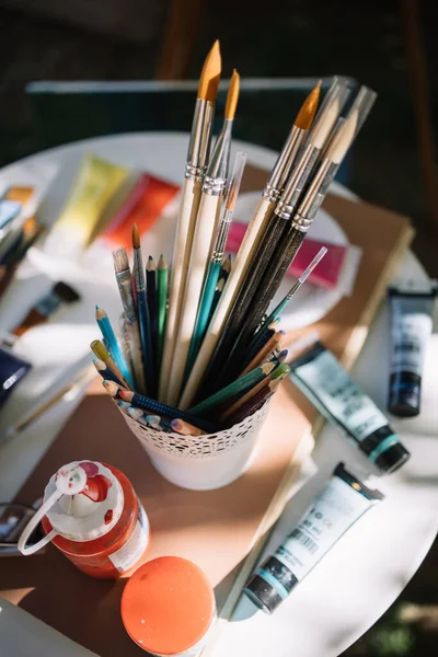 Pincéis de pintura em vaso com lápis coloridos — Fotografia de Stock