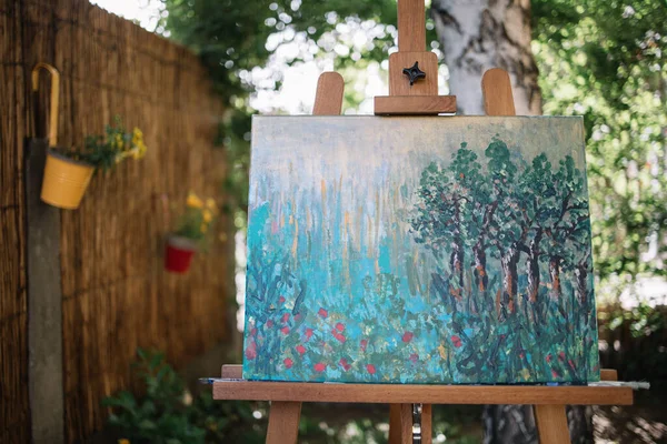 Pintura sobre tela colocada em stand no jardim — Fotografia de Stock