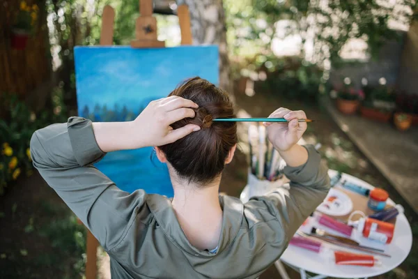Artista femenina haciendo peinado con pincel al aire libre — Foto de Stock